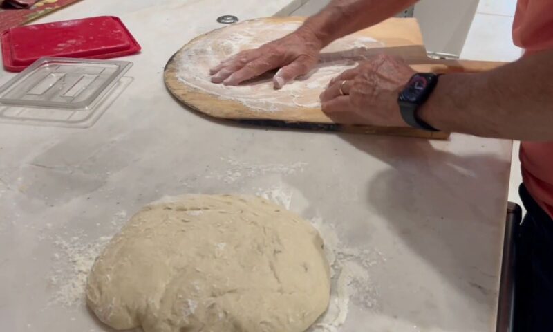 čovek oblikuje testo za picu